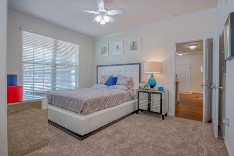 A bedroom with a large bed and a ceiling fan.