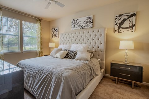 A bedroom with a large bed and a ceiling fan.