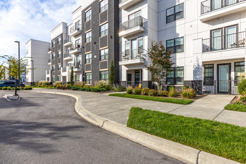 an empty parking lot in front of an apartment building