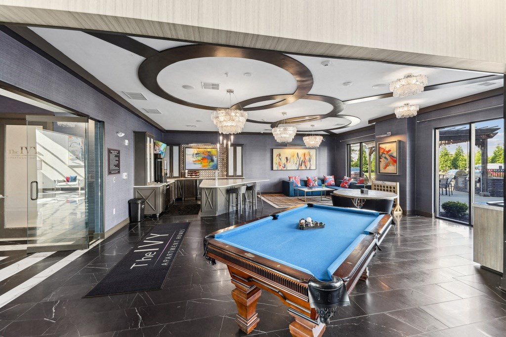 A pool table is in the middle of a room with a black and white floor.