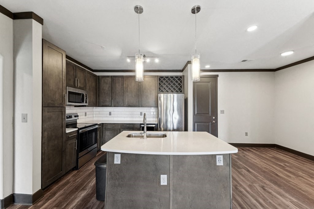 A modern kitchen with a center island and dark wood cabinets.