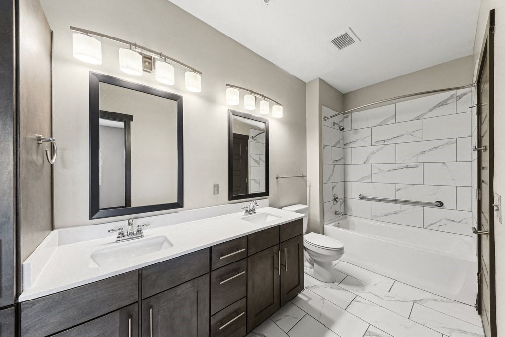 A bathroom with a white sink and a white toilet.