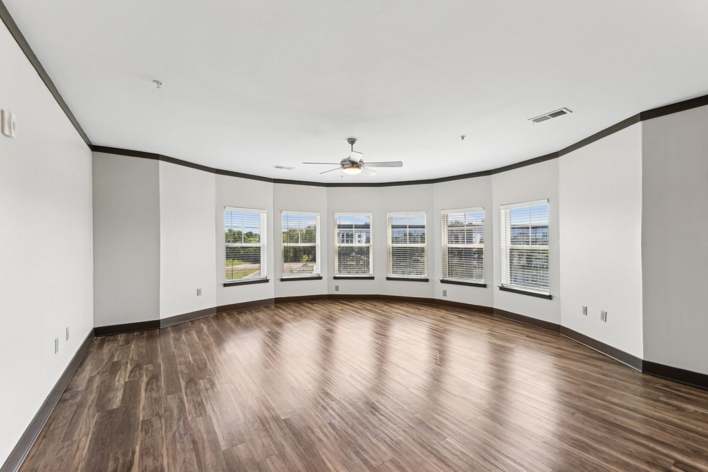 A room with wooden floors and a ceiling fan.