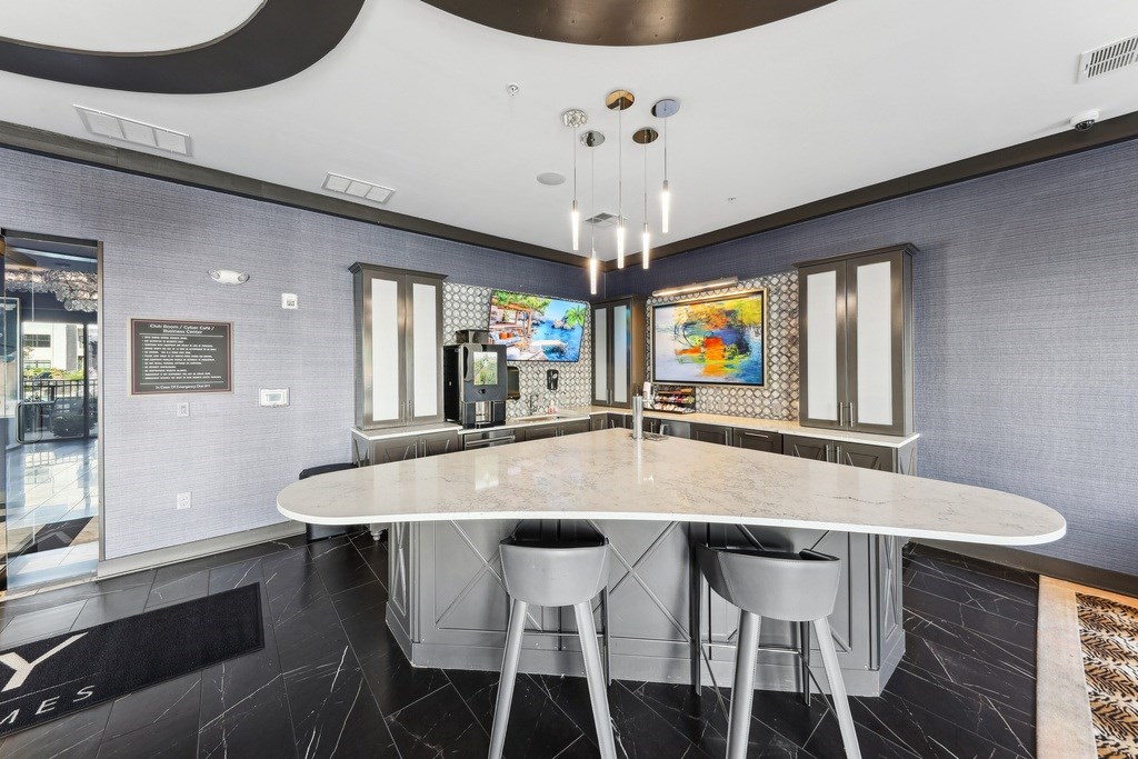A modern dining area with a white table and grey chairs.