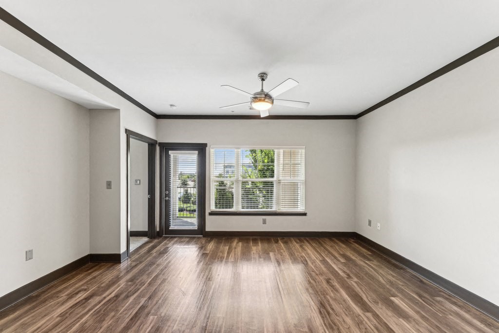 A room with a ceiling fan and a sliding glass door.