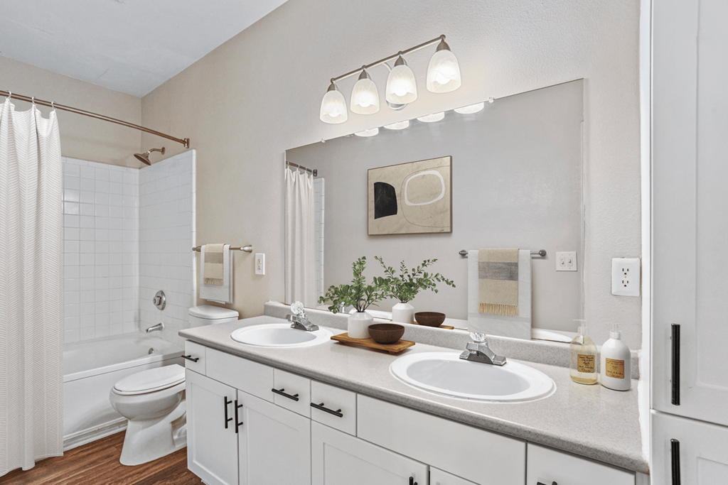 a bathroom with white cabinets and a white shower curtain