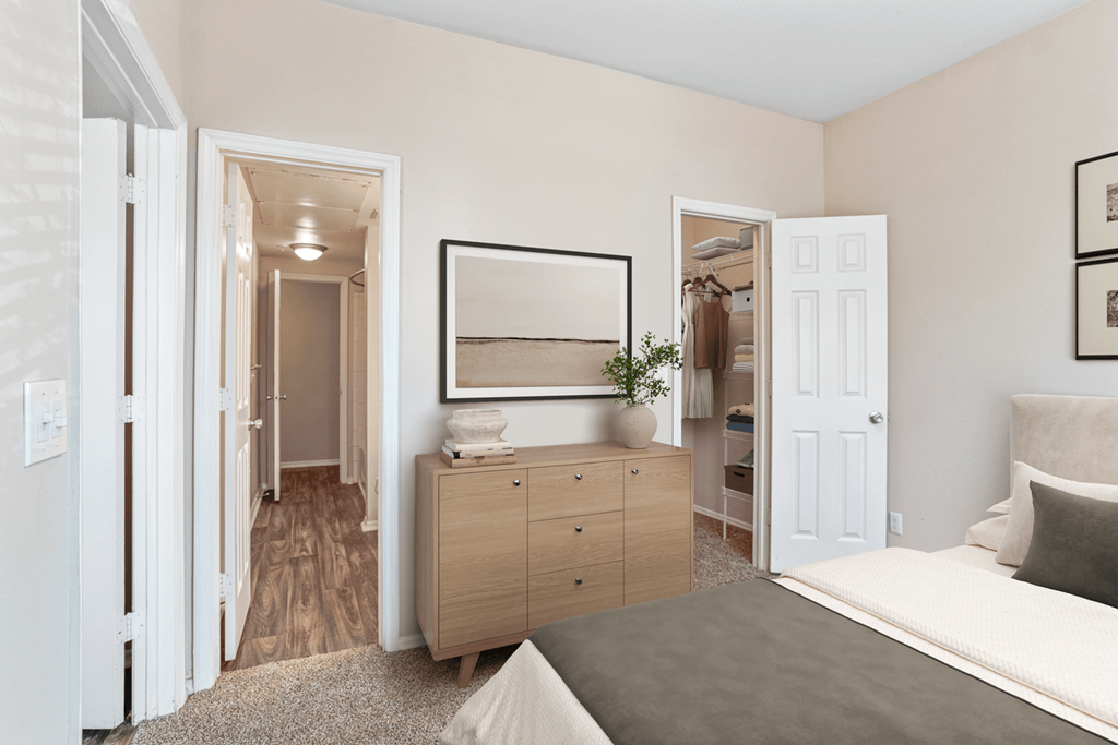 a bedroom with a bed and a dresser with a mirror on top of it