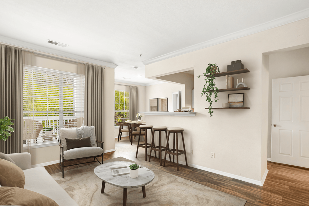 a living room with a bar and a dining room in the background