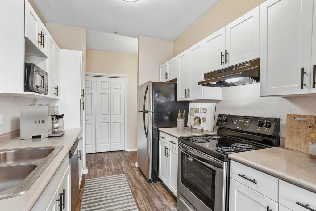 a kitchen with white cabinets and stainless steel appliances