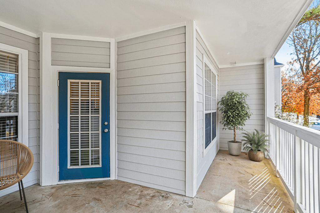 a front porch with a blue door and a potted plant