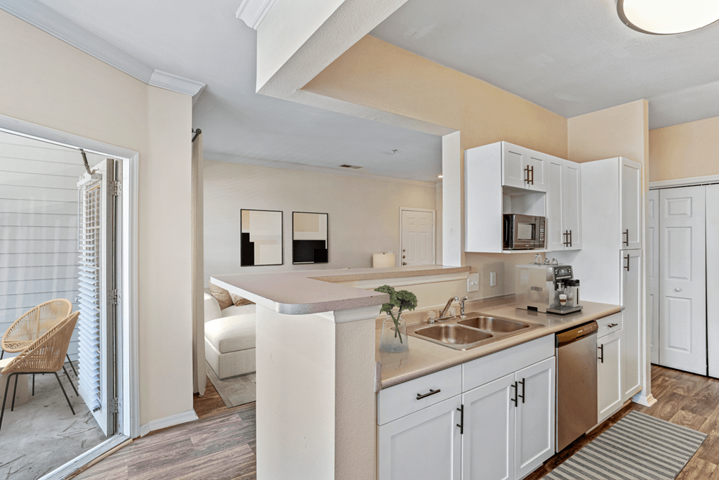 a kitchen with white cabinets and a stainless steel sink