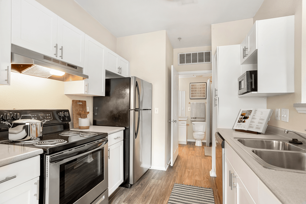 a kitchen with white cabinets and stainless steel appliances