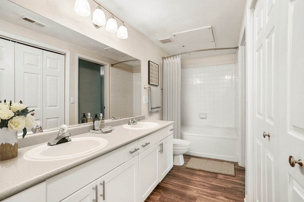 a bathroom with white cabinets and a white toilet