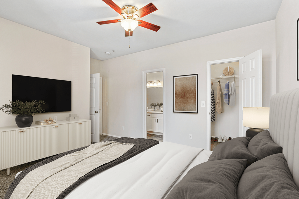 a bedroom with a large bed and a ceiling fan