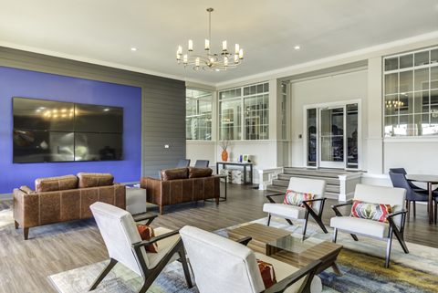 A living room with a brown couch and a white chair.