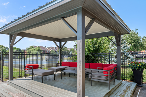 Outdoor pergola with lounge seating overlooking the community tennis courts