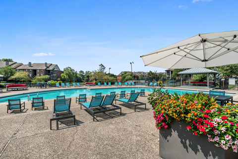 Swimming pool with teal lounge chairs wrapped around both sides