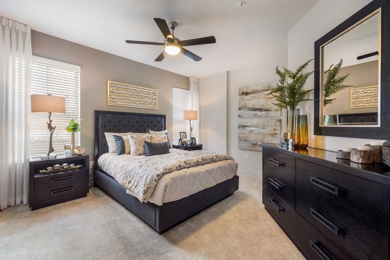 a bedroom with a bed and a ceiling fan