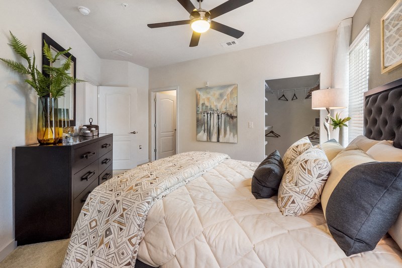 a bedroom with a large bed and a ceiling fan