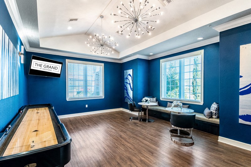 a game room with blue walls and a pool table and a chandelier