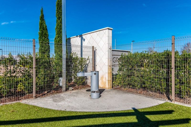 a fence with a gate and a toilet in front of a building