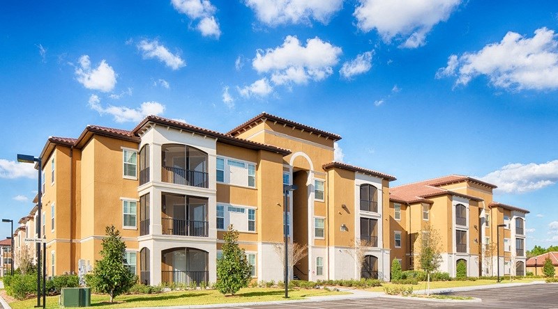 a row of apartment buildings with a blue sky in the background