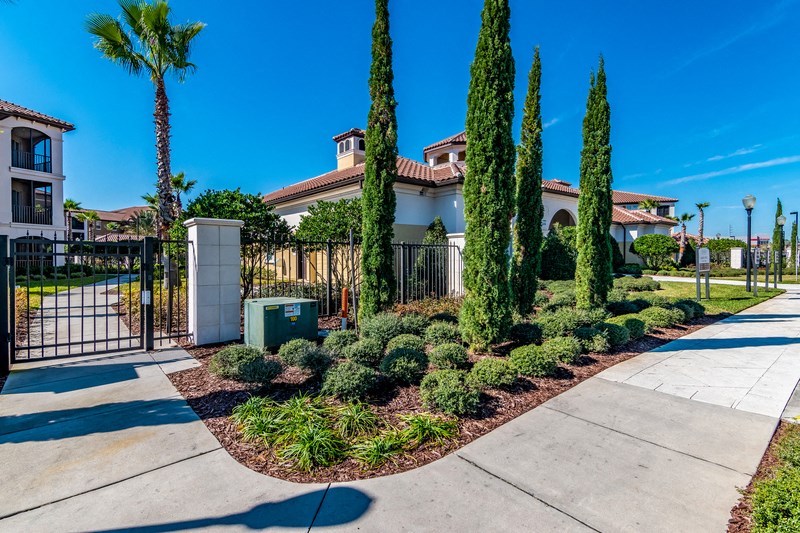a house with a fence and a sidewalk and trees