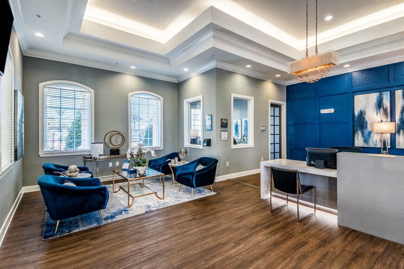 a living room with blue couches and chairs and a table