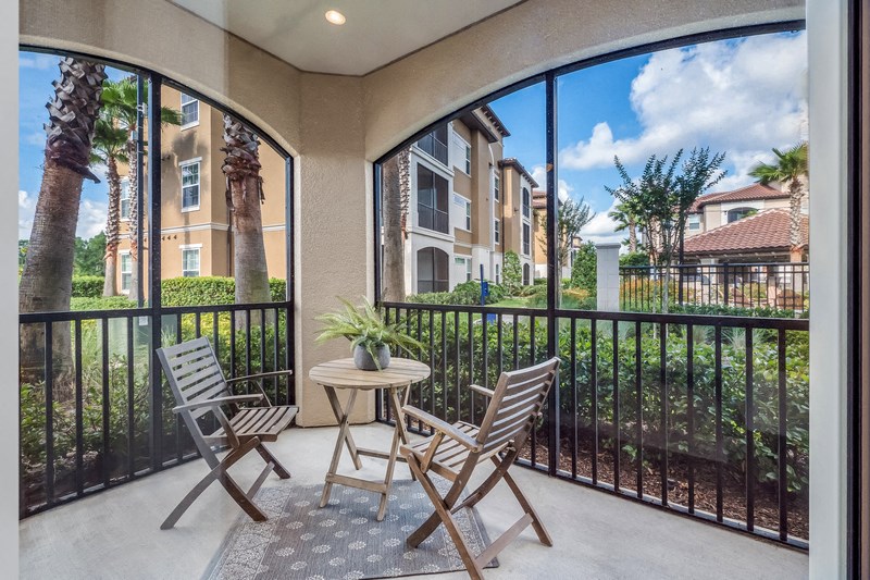 a patio with two chairs and a table on a balcony