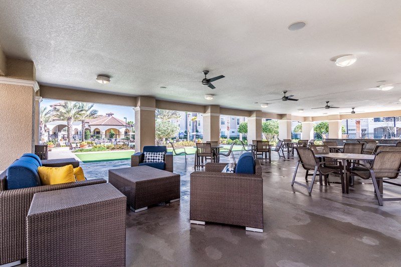 the lobby of a resort with tables and chairs and a pool