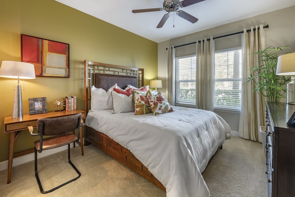 the master bedroom has a large bed and a ceiling fan