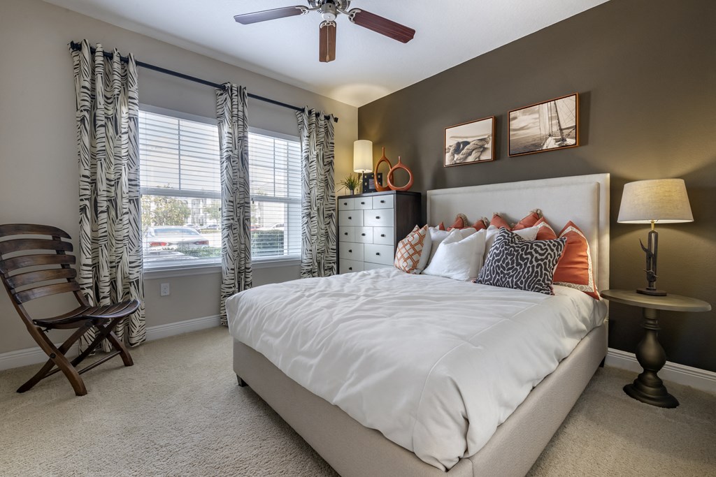 a bedroom with a large bed and a ceiling fan
