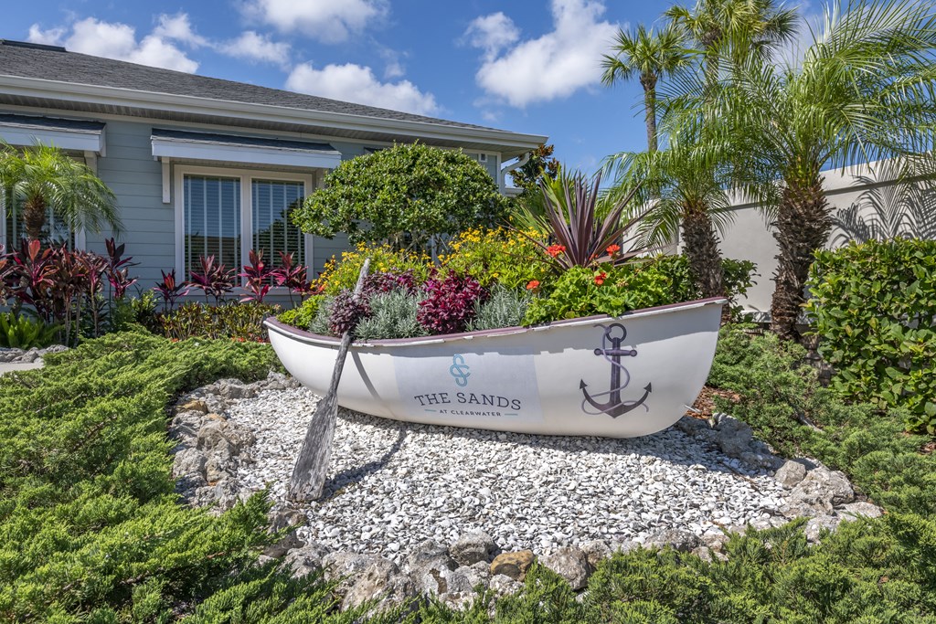 a boat parked in a garden in front of a house