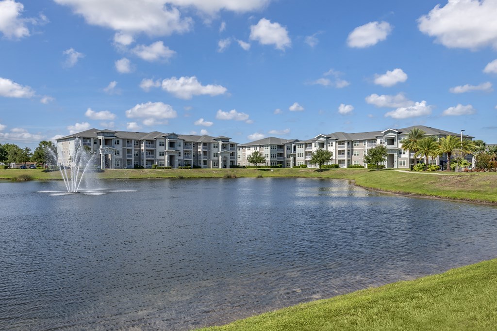 a pond with a fountain in front of a building