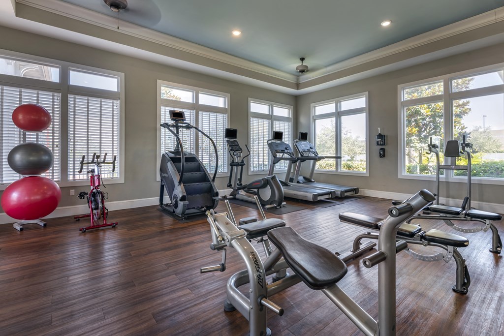 a home gym with exercise equipment and windows