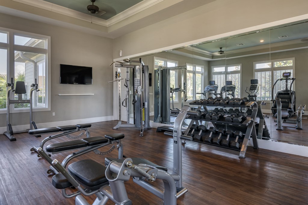 a gym with weights and cardio equipment in a home for sale