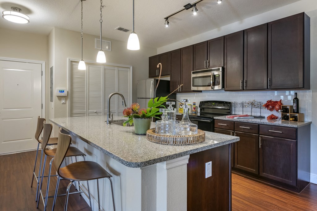 a kitchen with a marble counter top and wooden cabinets