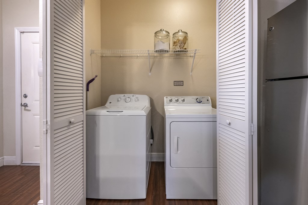 a washer and dryer in a laundry room with a refrigerator