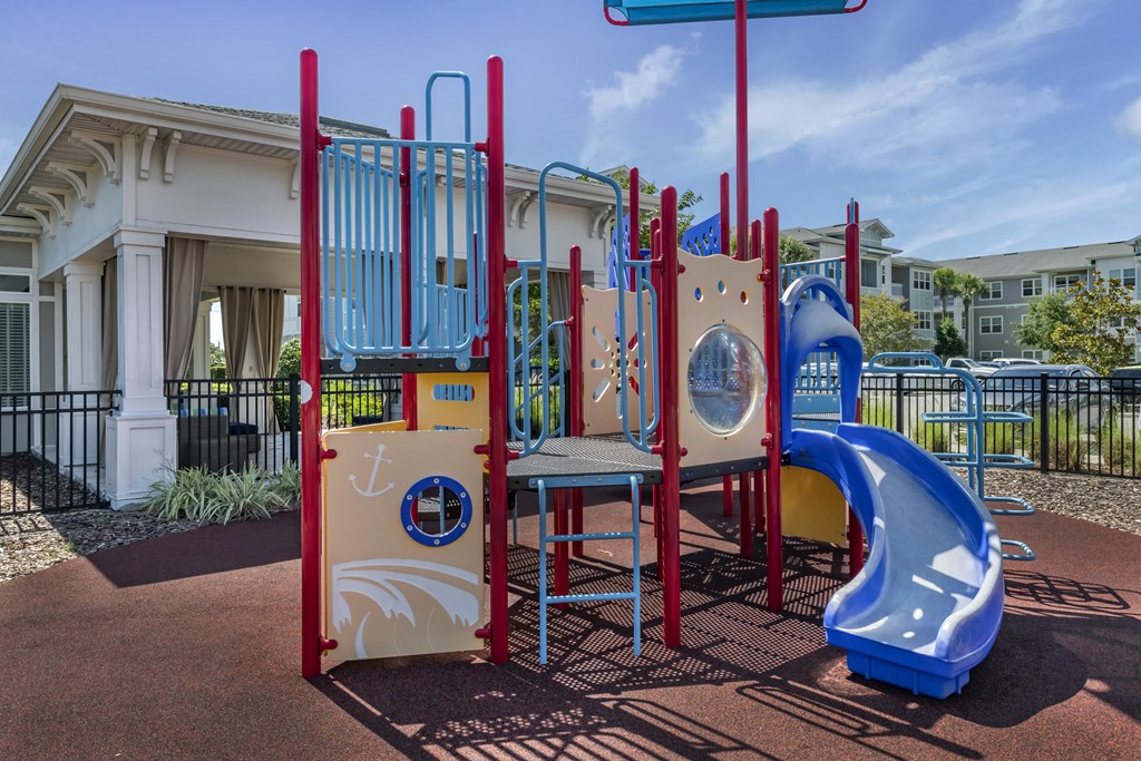 a playground with a slide and other playground equipment in front of a building