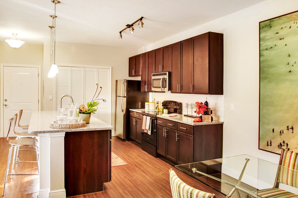 a kitchen with dark wood cabinets and a white counter top