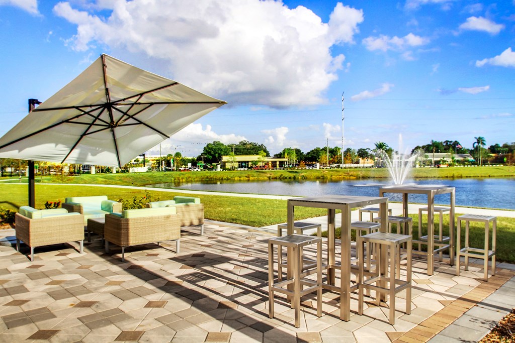 a patio with tables and chairs and a fountain