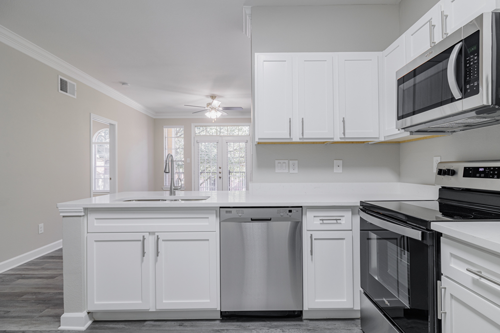 kitchen with white cabinetry, stainless appliances, and hardwood-style flooring