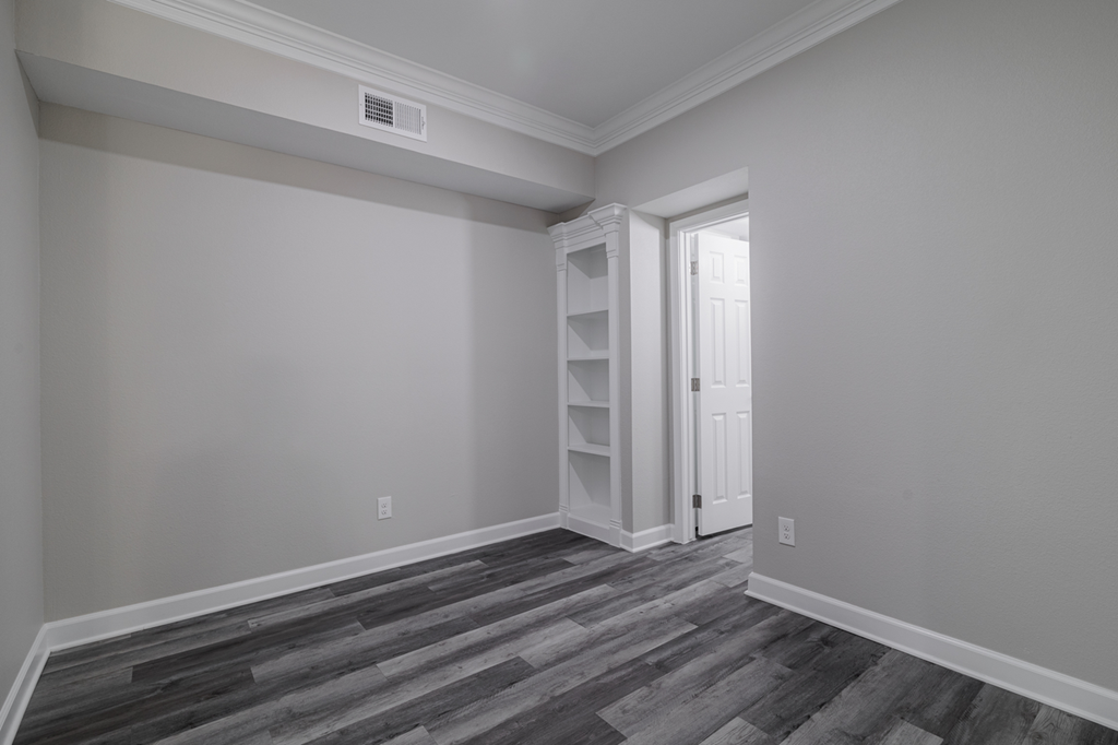 room with hardwood-style flooring and built-in shelving