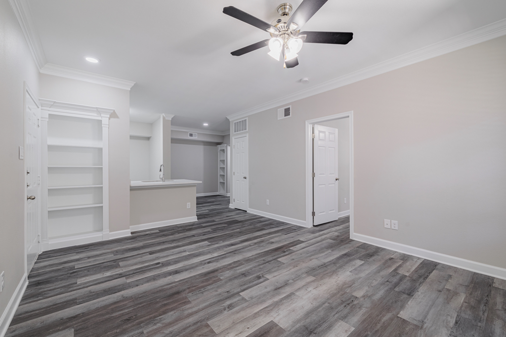 living room with ceiling fan and built-in shelving