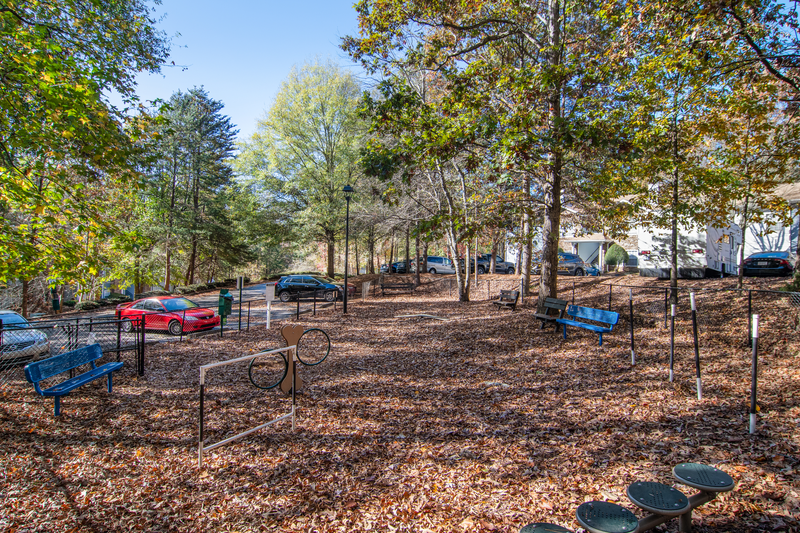 a fenced in park with benches and trees
