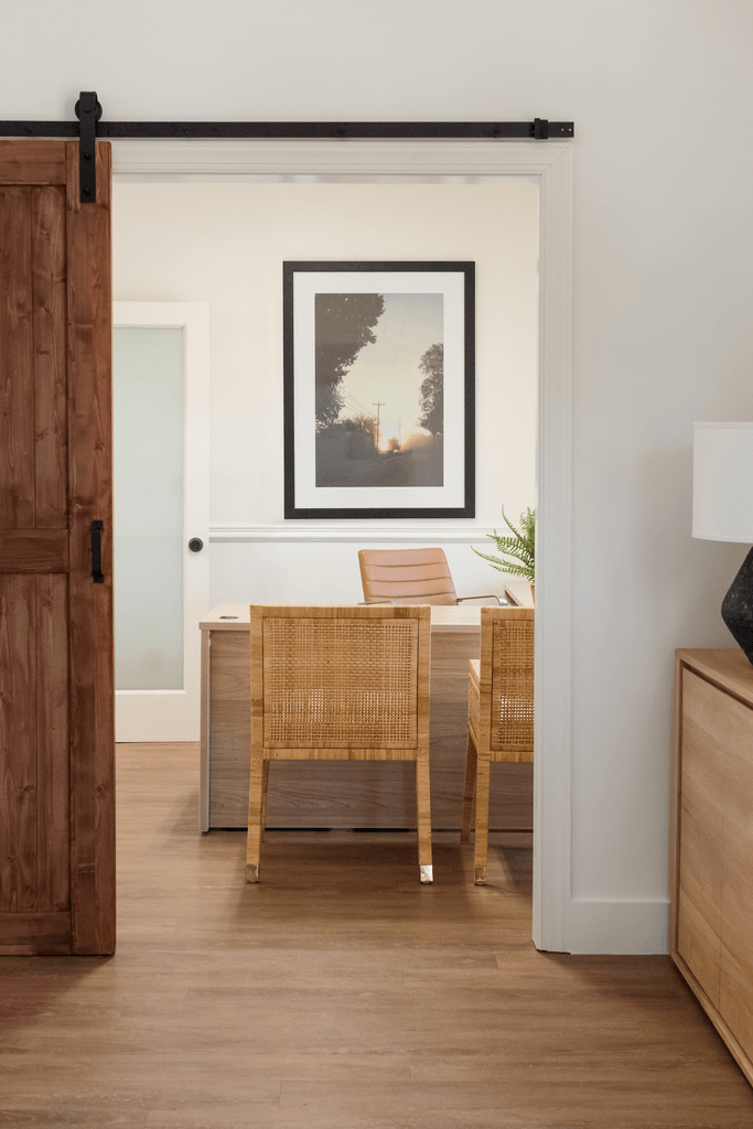 a dining room with a table and chairs and a painting on the wall