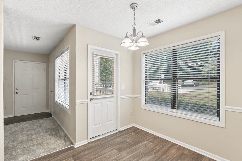an empty living room with a large window and a door