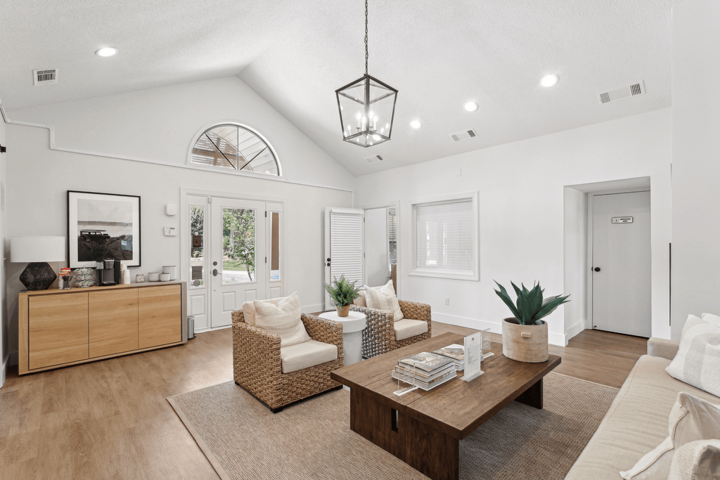 the living room of a new home with white walls and a wooden table