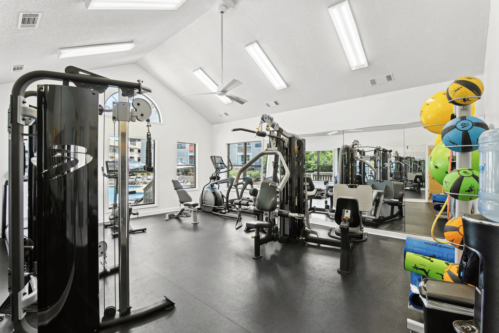 a gym with weights and cardio equipment in a building