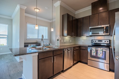 A kitchen with dark brown cabinets and stainless steel appliances.